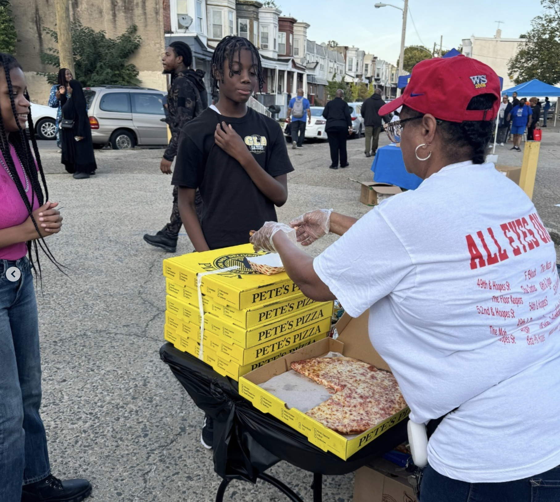 A volunteer hands out pizza on the street
